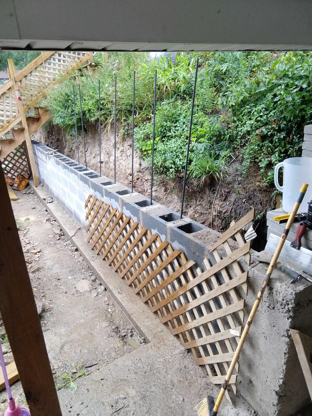 A concrete block retaining wall under construction.